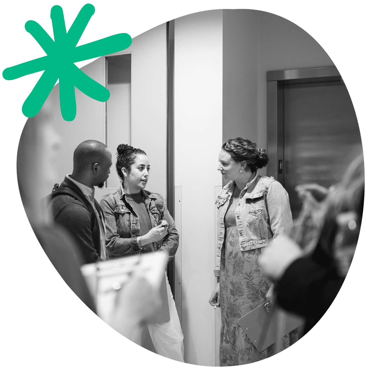 Three school leaders in conversation in a hallway during an All Means All convening.